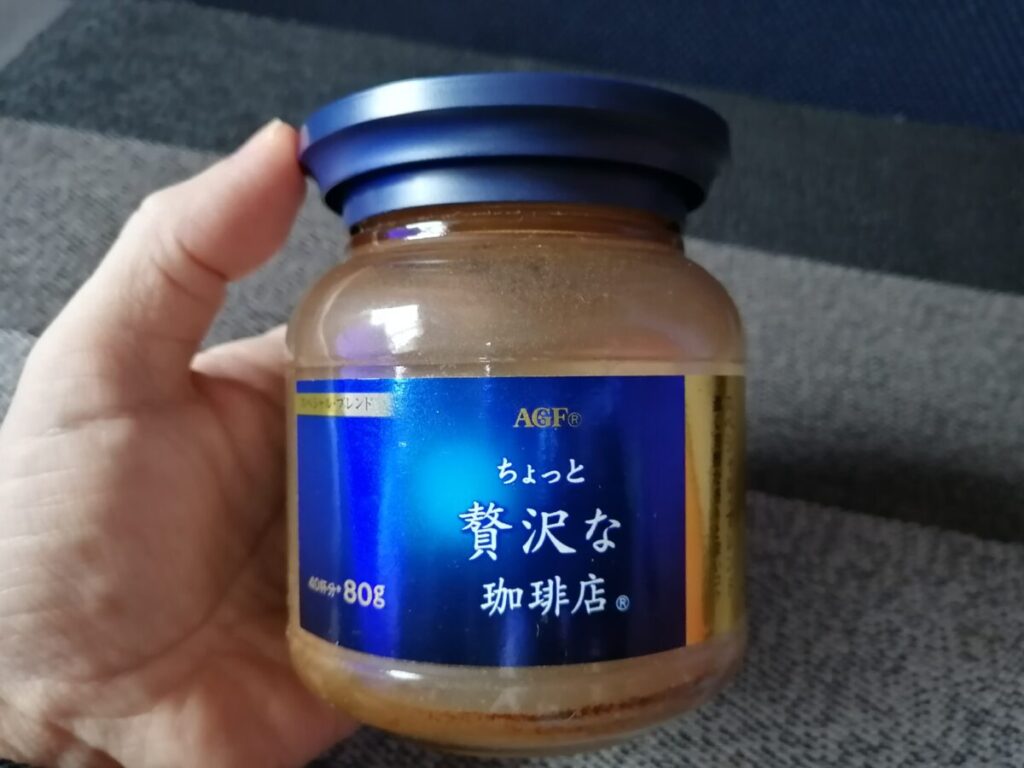 何度も詰め替えて大切に使っている年季の入ったコーヒーの瓶を手に持つ様子