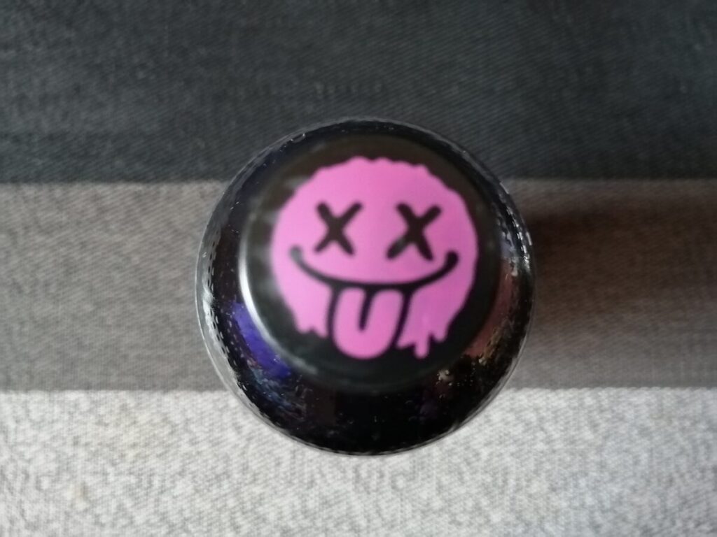 サントリーNOPEのペットボトルキャップ。ピンク色のバツ印の目をしたキャラクターのイラスト。