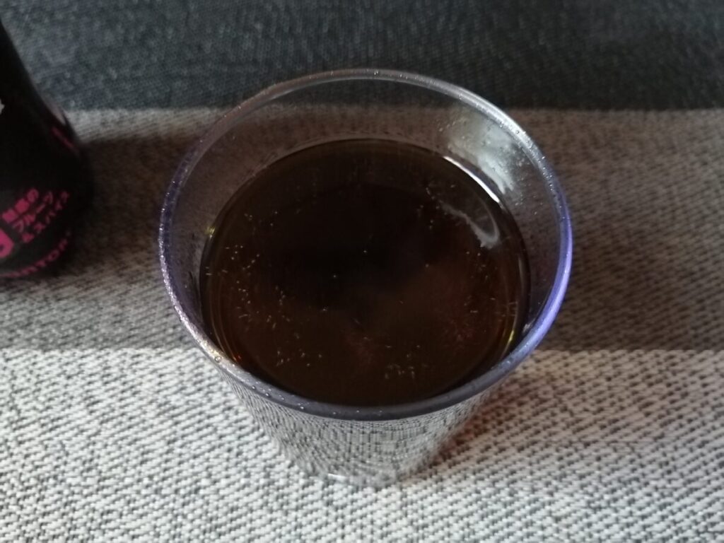 丸いウイスキーグラスに注がれた気泡が浮かぶNOPE。色はコーラに近い黒。炭酸は微炭酸。