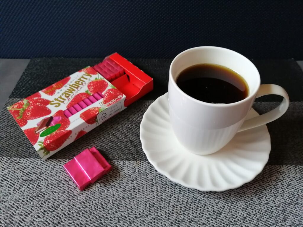白いカップに入ったAGFちょっと贅沢な珈琲店と、明治ストロベリーチョコレートが並んでいる様子。